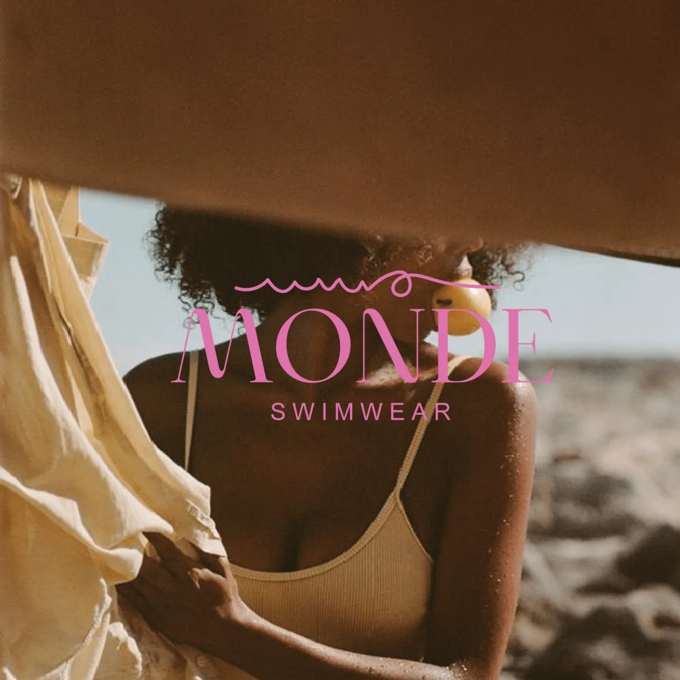 Logotipo de MONDE swimwear sobre fotografía de campaña